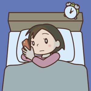 暗い中でスマホを見る女性